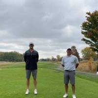 Four alumni taking picture on golf course
